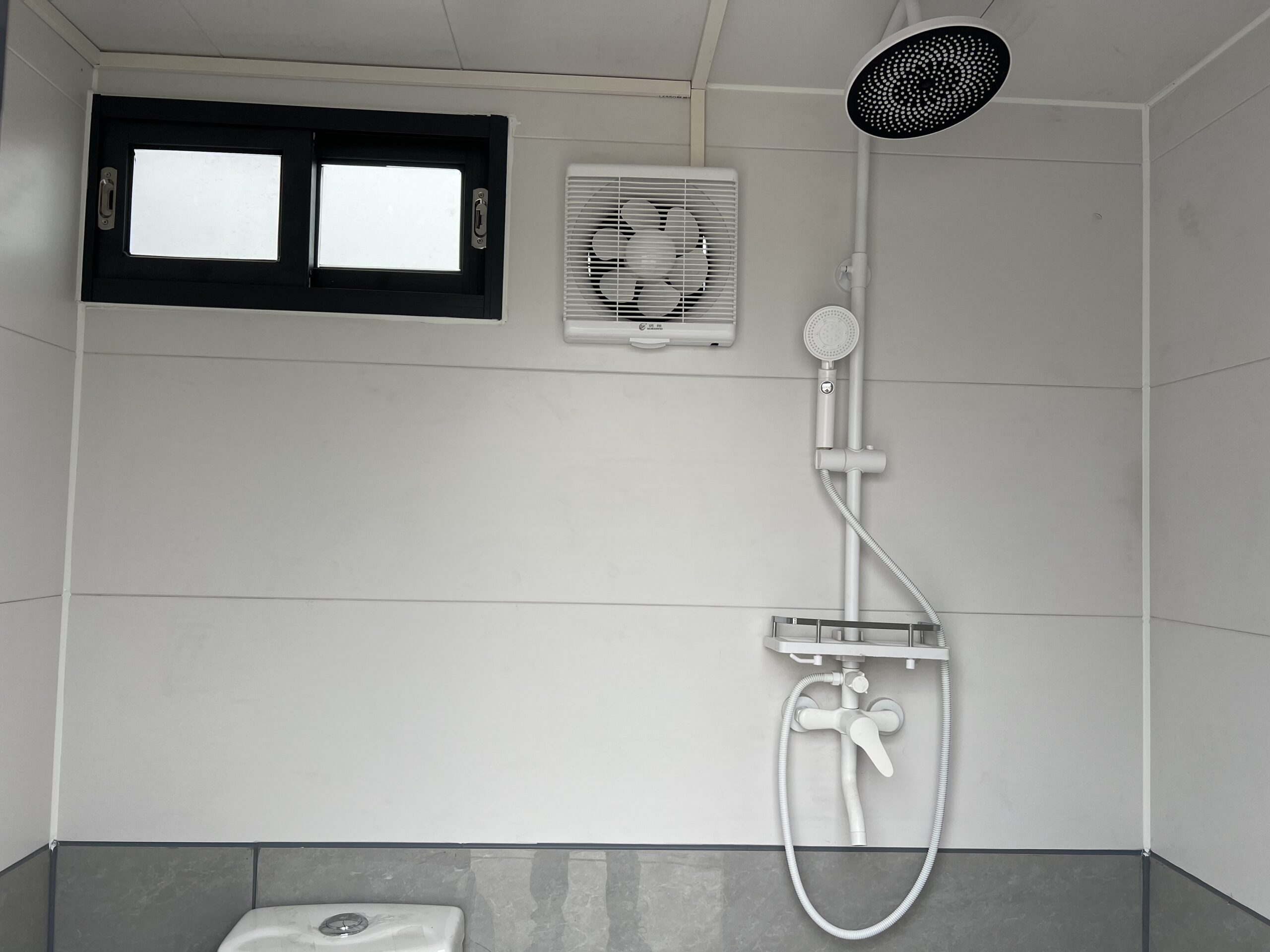 Professional team coordinating portable restroom trailer placement for efficient event service